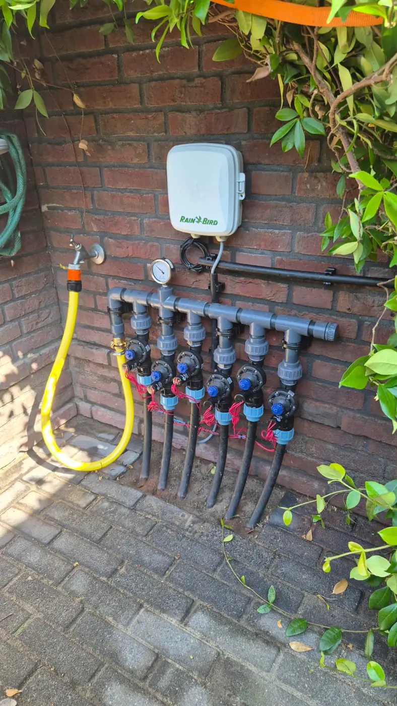 Verdeelunit met kleppen en besturing gemonteerd tegen een buitenmuur